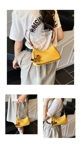 Detail of yellow baguette bag with brown leather trim and wooden horse charm on a model