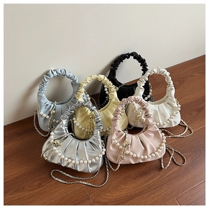 Detail view of colorful ruched cloud bags in six colors with pearl and metal chain straps