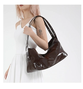 Detail of glossy brown leather shoulder bag with metallic silver stud embellishments