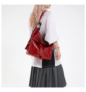 Detail der roten Lackleder-Schultertasche mit großer Schleife und silbernen Nieten