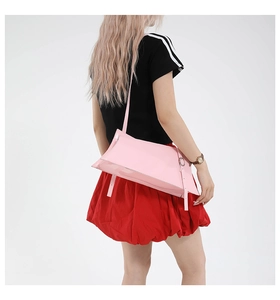 Détail du sac à bandoulière en cuir verni rose clair avec boucle et fine lanière