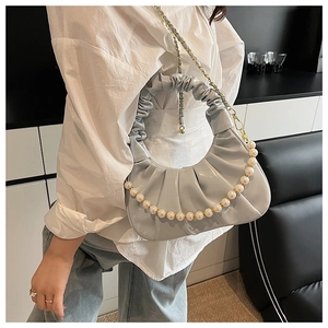 Detail of pleated cloud bag in light blue leather with pearl strap and gold chain