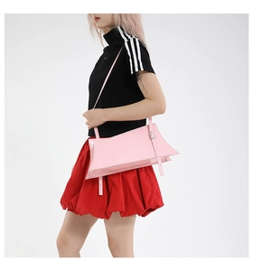 Pink patent leather geometric handbag with silver buckle shown from a side view on model