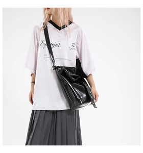 Black glossy tote bag with rivets styled with a pleated skirt and white print t-shirt
