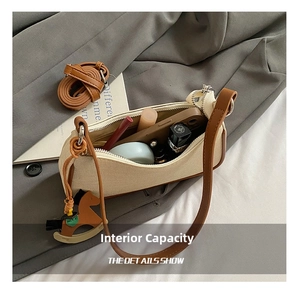 Detail view of beige canvas baguette bag interior showing capacity for phone and cosmetics