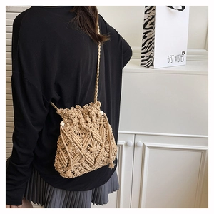 Detail of hand-woven beige crochet crossbody bag with wooden bead drawstring