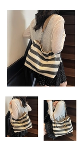 Detail of woven black and white striped tote bag with brown leather and chain strap