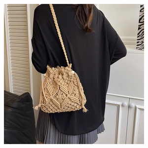 Detail of hand-woven macrame bucket bag showing beige texture and drawstring closure
