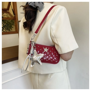Detail of red quilted patent leather shoulder bag with rhinestone studs and star charm