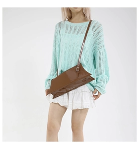 Sac bandoulière en cuir verni marron avec design géométrique porté par un mannequin