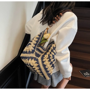 Detail of bohemian woven tote bag with geometric floral patterns and wood bead handles