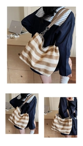 Close-up of woven straw tote with leather strap and chain detail for vacation style