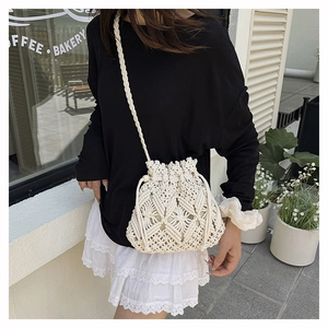 Detail of woven straw bucket bag with intricate cutout patterns and drawstring closure
