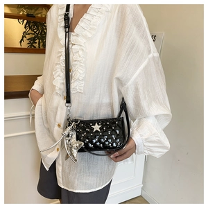 Close-up of quilted black crossbody bag with silver star studs and large star pendant