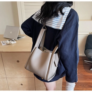 Close-up of elephant gray lychee leather bucket bag showing rich texture and commute style