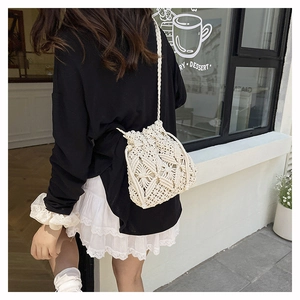 Close-up of beige crochet bucket bag showing intricate woven texture and drawstring detail