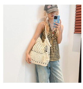 Detail of crochet tote bag featuring hollow knit pattern and fringe tassels for beach