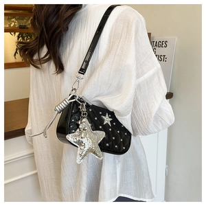 Close-up of black patent leather crescent bag with silver star sequins and rhinestones