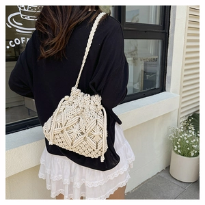 Detail of bohemian macrame crochet bucket bag with drawstring and woven shoulder strap