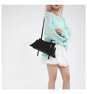 Détail du sac à bandoulière en cuir verni noir avec sangle réglable et boucle argentée
