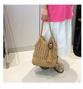 Detail of hand-woven cotton tote bag featuring bohemian tassels and black bead accents