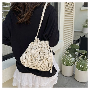 Detailed view of cream macrame bucket bag with hand-woven patterns and drawstring beads