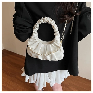 Detail of white pleated cloud bag featuring elegant pearl chain and soft faux leather texture