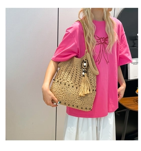 Detail of hand-woven crochet tote bag featuring intricate hollow patterns and wood bead tassels