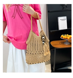 Close-up of handmade crochet tote bag with decorative wooden beads and long tassels