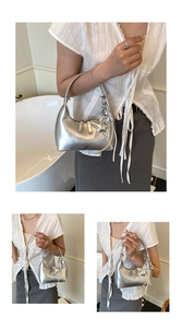 Close-up of metallic silver hobo bag featuring a star pendant and fringe detail