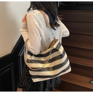 Détail du sac fourre-tout tissé à rayures avec bandoulière en cuir et chaîne