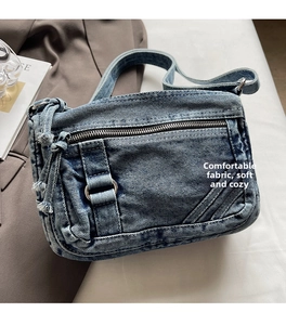 Detail of vintage denim crossbody bag featuring textured fabric and leather strap accents