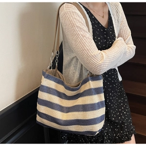Détail du grand sac cabas tissé à rayures bleues et beige avec sangle en cuir et chaîne