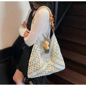 Detail of woven tote bag featuring hollow diamond patterns and wooden bead handle accents