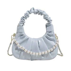 Pale blue pleated cloud handbag with pearl chain and metallic shoulder strap on white backdrop