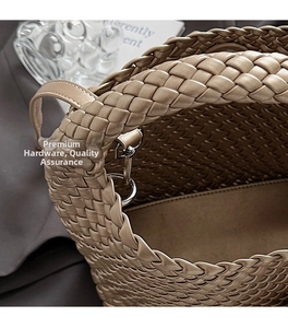 Close-up of champagne gold woven handbag showing metallic texture and silver metal buckle