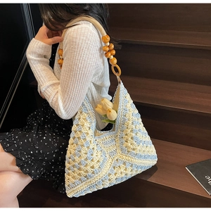 Detailed shot of crochet shoulder bag with blue wave pattern and orange wooden beads