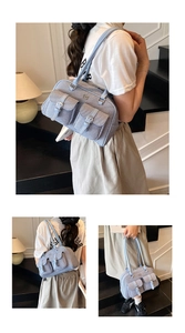 Detail of light blue textured pillow bag with front buckle pockets and leather straps