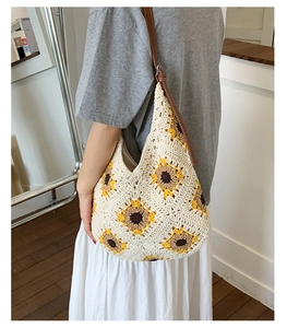 Detail of hand-crocheted sunflower knit hobo bag with adjustable brown leather strap