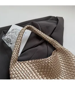 Detail of champagne gold woven hobo bag showing fine leather texture and strap