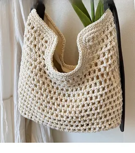 Detail of woven mesh cotton bag featuring premium leather strap and beige lining