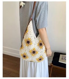 Detail of hand-knitted sunflower tote bag with cream cotton yarn and brown leather strap