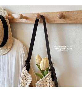 Detail of adjustable leather strap with metal buckle on a woven cotton crochet tote bag