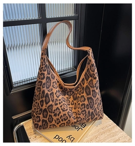 Detail der Vintage-Leopard-Tragetasche mit braunen Leder-Schultergurten auf einem Sockel