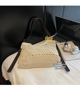 Detail of hand-woven cream cotton tote bag with premium brown leather straps on white bedding