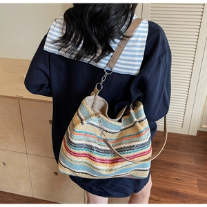 Détail d'un grand sac cabas tissé coloré avec bandoulière en cuir et maillons dorés