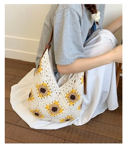 Detailed close-up of handmade sunflower knit tote bag with leather strap and soft fabric lining