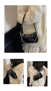 Détail du sac à bandoulière en cuir verni noir brillant avec chaîne et fermeture argentée