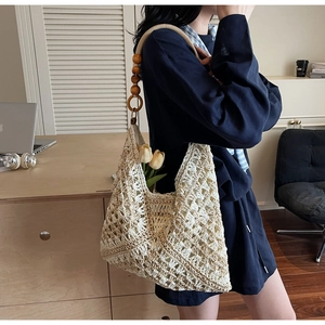 Detail of hand-woven crochet tote bag featuring vintage wooden bead straps and floral pattern