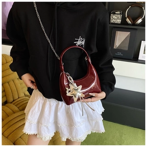 Deep red patent leather handbag with silver star charm and chain strap detail